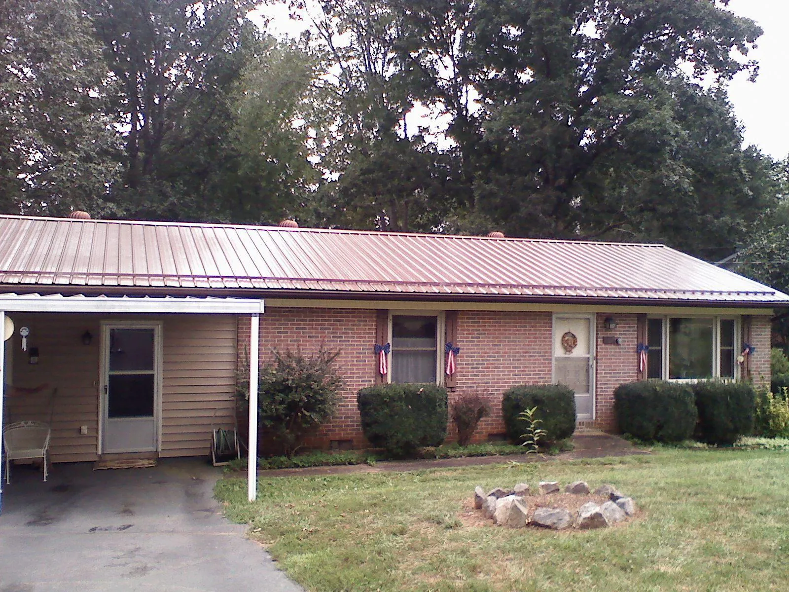 Bronze metal roof and carport on a brick ranch home — Roof Repair work by our crew in Represa
