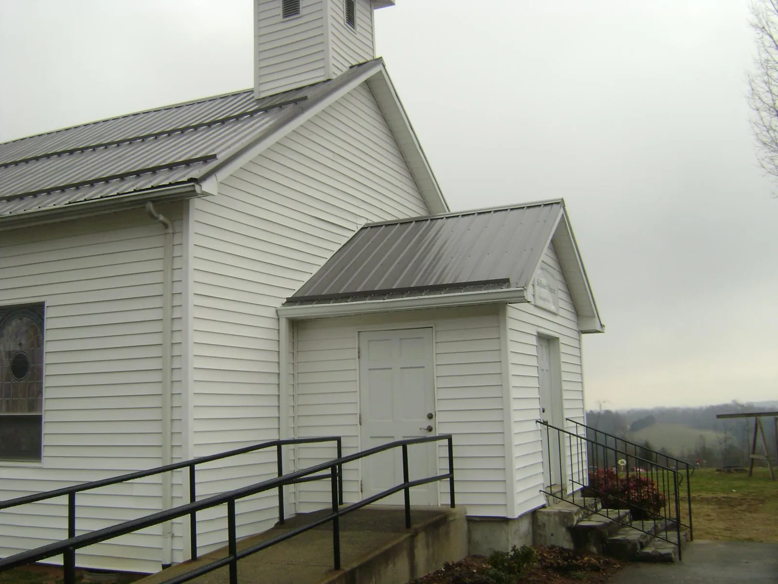 Gray metal roof on a white clapboard church with a steeple in Represa